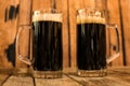 Two glass of fresh dark beer on wooden table Royalty Free Stock Photo