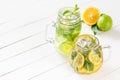 Two glass glasses with homemade lemonade from lime and lemon, sliced citrus on a white wooden rustic background Royalty Free Stock Photo