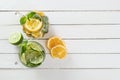 Two glass glasses with homemade lemonade from lime and lemon, sliced citrus on a white wooden rustic background Royalty Free Stock Photo