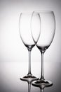 Two glass goblet without wine on a thin leg stands on a mirror surface Royalty Free Stock Photo