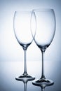 Two glass goblet without wine on a thin leg stands on a mirror surface Royalty Free Stock Photo