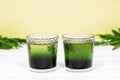 Two glass with Green Chlorophyll on white table, Orange Background. Antioxidant drinks, Superfood Royalty Free Stock Photo