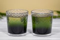 Two glass with Green Chlorophyll on white table, Orange Background. Antioxidant drinks, Superfood Royalty Free Stock Photo