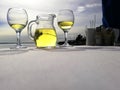 Two glass and jag with white wine on the table near the sea