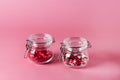 Two Glass Jars with Candy Sprinkles in Shape of Hearts and Lips on Pink Background Horizontal Royalty Free Stock Photo