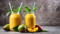 Two glass jars filled with orange juice and a cut open mango Royalty Free Stock Photo