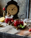Two glass jars with homemade canned strawberry jam, marmalade, jelly on rustic wooden grey table with basil Royalty Free Stock Photo
