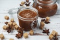 Two glass jars of homemade caramel with crystals of salt, pieces of cane sugar and star anise Royalty Free Stock Photo