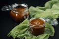 Two glass jars of homemade caramel with salt crystals on green gauze Royalty Free Stock Photo