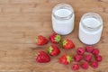 Two glass jars with yogurt, raspberries and strawberries horizontal high angle view. Royalty Free Stock Photo