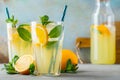 Two glass with lemonade or mojito cocktail with lemon and mint, cold refreshing drink or beverage with ice on rustic blue Royalty Free Stock Photo