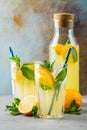 Two glass with lemonade or mojito cocktail with lemon and mint, cold refreshing drink or beverage with ice on rustic blue Royalty Free Stock Photo