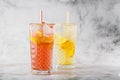 Two glass with lemonade and orange cocktail with lemon and orange, cold refreshing drink or beverage with ice on bright marble Royalty Free Stock Photo