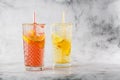 Two glass with lemonade and orange cocktail with lemon and orange, cold refreshing drink or beverage with ice on bright marble Royalty Free Stock Photo