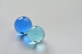 two glass marbles reflecting light from their blue and aqua colors Royalty Free Stock Photo