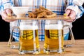 Two glass mugs with beer against the background of a girl with beer snacks on a serving board. Royalty Free Stock Photo