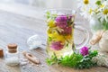 Two glass mugs of healthy herbal tea or infusion, bottles of homeopathic globules .
