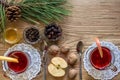 Two glass of mulled wine with cinnamon sticks, slice of oranges and apple, star anise on a wooden table Royalty Free Stock Photo