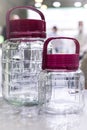 Two glass new empty jars containers with plastic lid handle on the table for storing canned bulk foods and liquids, household