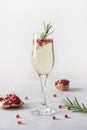 Pomegranate Christmas cocktail with rosemary, champagne, club soda on grey table. Xmas Holiday drink Royalty Free Stock Photo