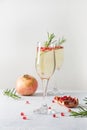 Pomegranate Christmas cocktail with rosemary, sparkling wine on white table. Xmas Holiday drink Royalty Free Stock Photo