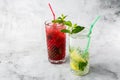 Two glass with strawberry and classic mojito cocktail with lemon and mint, cold refreshing drink or beverage with ice on bright Royalty Free Stock Photo