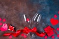 Two glass of wine, hearts and gift box on stone background. Romantic still life. Valentine`s Day with copy space, flat Royalty Free Stock Photo