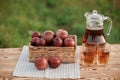 Two glasses with apple juice and basket with apples on wooden table with natural orchard background. Vegetarian fruit composition Royalty Free Stock Photo