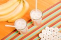 Two glasses of banana juice on the table next to a yellow ripe b Royalty Free Stock Photo