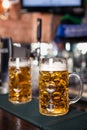 Two glasses of beer on a bar table. Beer tap on background