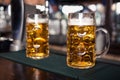 Two glasses of beer on a bar table. Beer tap on background