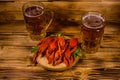 Two glasses of beer and boiled crayfish on wooden table Royalty Free Stock Photo