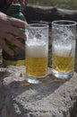 Two glasses of beer, men`s hands and  plastic green bottle Royalty Free Stock Photo