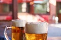 Two glasses of beer standing on a table in a garden pub on a sum Royalty Free Stock Photo