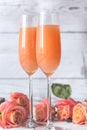 Two glasses of bellini cocktail with bouquet of roses