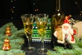 Two glasses, a bottle of wine and a toy Santa Claus