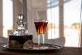 Two glasses an a carafe filled with red sherry in a room with a lot of sun, Namibia. Royalty Free Stock Photo