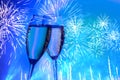 Two glasses of champagne on the background of the festive salute, fireworks of neon color.