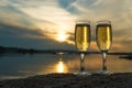 Two glasses with champagne on the background of the sunset, in nature, outdoors. Royalty Free Stock Photo