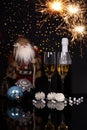 Two glasses champagne, bottle, Santa Claus and Christmas sparkle Royalty Free Stock Photo