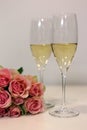 Two glasses of champagne and a bouquet made of beautiful light red / blush pink roses Royalty Free Stock Photo