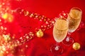 Two glasses of champagne and chocolate in golden wrapper on a red velvet background Royalty Free Stock Photo