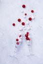 Two glasses for champagne and Christmas champagne bottle with sprinkles in the form of Christmas tree made of red and white toys Royalty Free Stock Photo