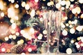 Two glasses of champagne with Christmas tree background and sparkles. Holiday season background. Traditional red and green Royalty Free Stock Photo