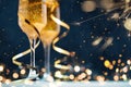 Two glasses of champagne with golden confetti, glitter, serpentine and lights. Royalty Free Stock Photo