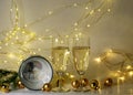 Two glasses of champagne, golden glass balls and various Christmas decorations, illuminated background of a chain of white lights Royalty Free Stock Photo