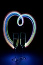 Two glasses of champagne in heart-shaped neon light Royalty Free Stock Photo