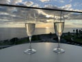 Two glasses of champagne at hotel balcony with view of sea and skyline, luxury romantic dinner for couple Royalty Free Stock Photo