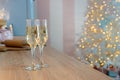 Two glasses of champagne on a kitchen. Christmas New year background and decoration, light bokeh effect and light garland Royalty Free Stock Photo