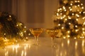 Two glasses of champagne are on the New Year\'s table. Christmas tree with garlands Royalty Free Stock Photo